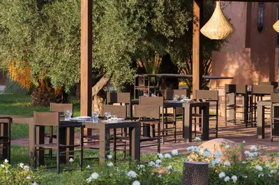 a group of tables and chairs in a garden at Ecolodge Quaryati Marrakech in Douar Tounsi