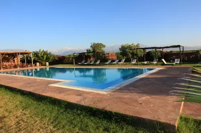 a large swimming pool with chairs in a yard at Ecolodge Quaryati Marrakech in Douar Tounsi