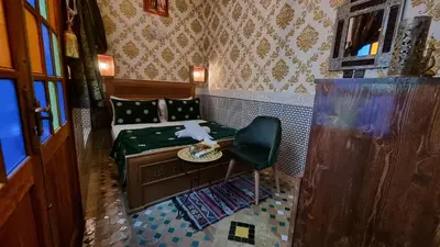 a small room with a bed and a chair at Riad Fes Touria Palace in Fès