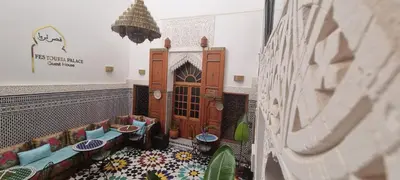 a room with couches and plants in a building at Riad Fes Touria Palace in Fès