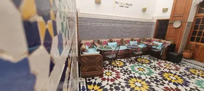 a restaurant with tables and chairs in a room at Riad Fes Touria Palace in Fès