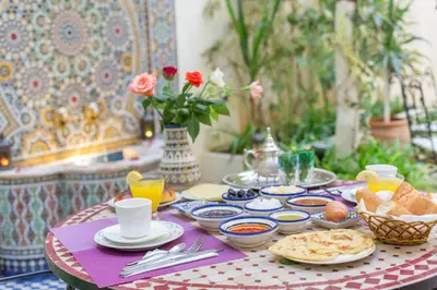 a table with plates of food on a table at Riad Jardin Chrifa in Fès