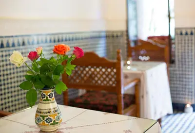 a vase with flowers in it sitting on a table at Riad Jardin Chrifa in Fès