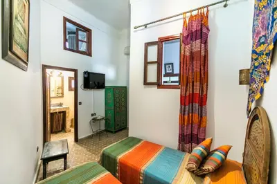 a room with two beds and a window at Riad Jardin Chrifa in Fès