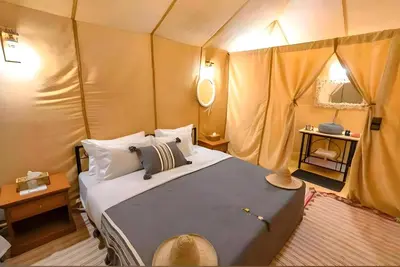 a bedroom with a bed in a tent at Luxurious Merzouga Desert Camps in Merzouga