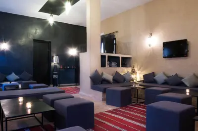 a living room with blue couches and a tv at Dar Chamaa in Ouarzazate