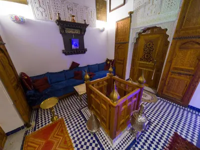 a living room with a blue couch and a table at Dar Mfaddel in Fès