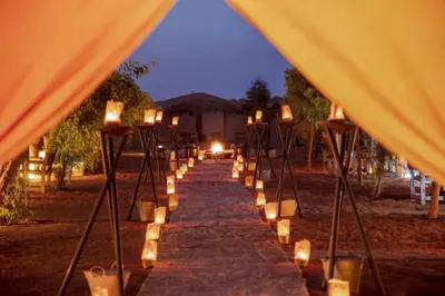 a long aisle with candles and lights under a tent at Erg Chebbi Camp in Merzouga