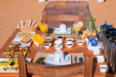 a table with breakfast foods and drinks on it at Erg Chebbi Camp in Merzouga