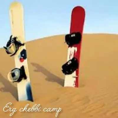 a snowboard stuck in the sand in the desert at Erg Chebbi Camp in Merzouga