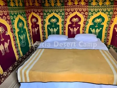 a bedroom with a bed with a painting on the wall at Acacia Desert Camp in Merzouga