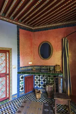 a room with a fireplace and a mirror on the wall at Riad Jardin Des Biehn in Fès