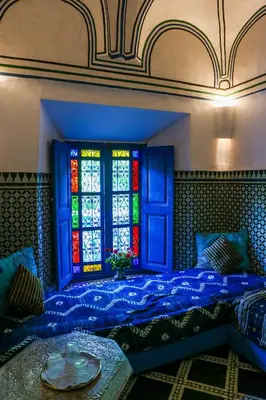 a bedroom with a bed with a stained glass window at Riad Jardin Des Biehn in Fès