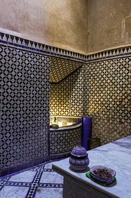 a tiled room with a table and a sink at Riad Jardin Des Biehn in Fès
