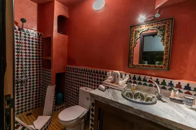 a bathroom with a toilet and a sink and a mirror at Dar Fes Tresor in Fès