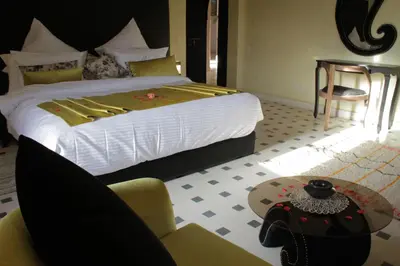 a bedroom with a bed and a table and a chair at Kasbah ATFEL in Ourika
