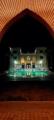 a building with a pool in front of it at night at Kasbah ATFEL in Ourika