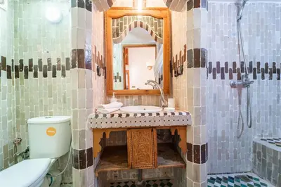a bathroom with a sink and a toilet and a mirror at Riad Taj Salma in Fès