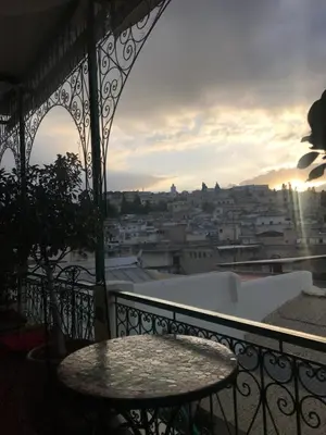 a balcony with a table and a view of a city at Riad Taj Salma in Fès