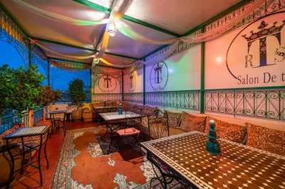a restaurant with tables and chairs in a room at Riad Taj Salma in Fès