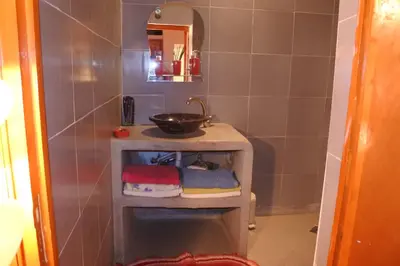 a bathroom with a sink and a bowl on a shelf at Le jardin d'habiba in Rhorm el Alem