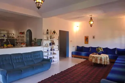 a living room with blue couches and a table at Le jardin d'habiba in Rhorm el Alem