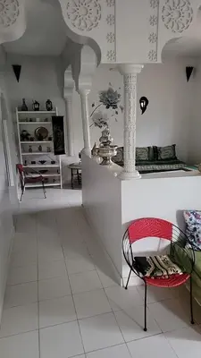 a living room with a table and a chair at Le jardin d'habiba in Rhorm el Alem
