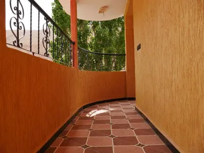 a hallway with a balcony with a large window at Hotel Baddou in Tamtetoucht