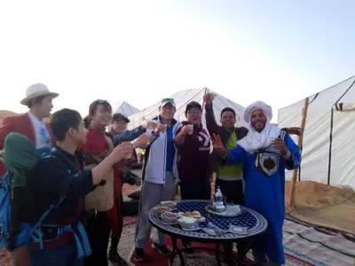 a group of people standing around a table with drinks at Merzouga Luxury Bivouac in Merzouga