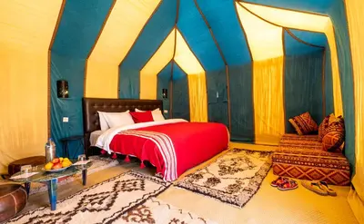 a bedroom with a bed in a tent at Merzouga Luxury Bivouac in Merzouga