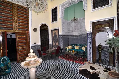 a living room filled with furniture and a chandelier at Riad Khouloud in Fès