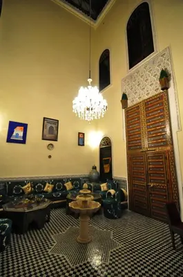 a living room with a couch and a chandelier at Riad Khouloud in Fès