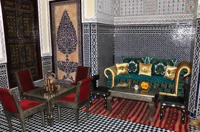 a living room with a couch and a table and chairs at Riad Khouloud in Fès