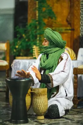 a man in a green hijab sitting on the floor at Riad Naila & suite in Fès