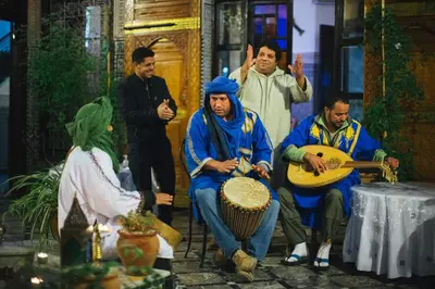 a group of men playing instruments on a stage at Riad Naila & suite in Fès