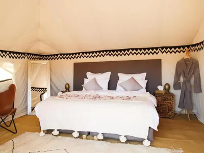 a bedroom with a large bed in a tent at Nubia Luxury Camp Erg Chegaga in El Gouera