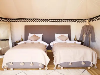 a bedroom with two beds in a tent at Nubia Luxury Camp Erg Chegaga in El Gouera
