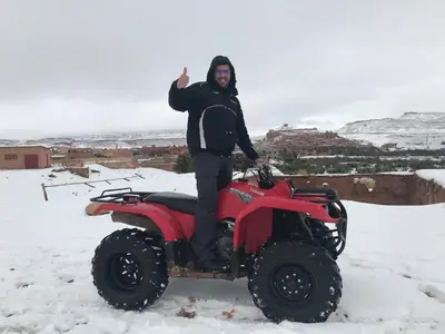 a man standing on a four wheeler in the snow at Kasbah Rayane Ait Ben Haddou in Aït Ben Haddou