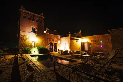 a building with a swimming pool at night at Kasbah Rayane Ait Ben Haddou in Aït Ben Haddou