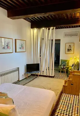 a bedroom with a bed and a living room at La Maison Maure in Fès