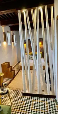 a room with a staircase with white poles at La Maison Maure in Fès