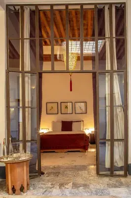 a bedroom with a bed and a large glass doorway at La Maison Maure in Fès