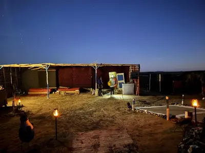 a tent with lights in a yard at night at Obira Oasis Merzouga Camp in Merzouga
