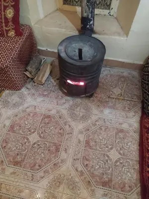 a wood stove on a floor in a room at Palmeraie Guest House in Tinerhir