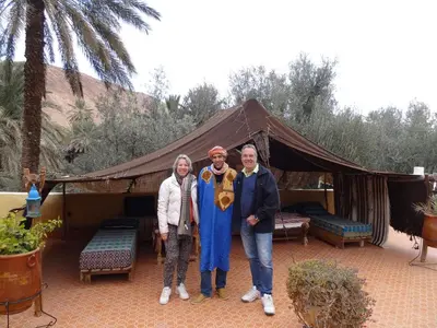 a group of three people standing in front of a tent at Palmeraie Guest House in Tinerhir