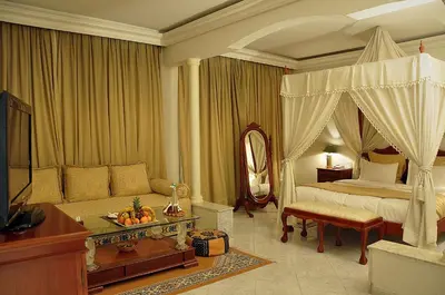 a bedroom with a canopy bed and a couch at Zalagh Parc Palace in Fès