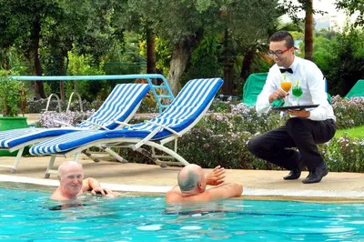 two men in a swimming pool with a man holding a drink at Menzeh Zalagh City Center in Fès