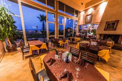 a restaurant with tables and chairs and a large window at Menzeh Zalagh City Center in Fès