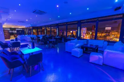 a restaurant with blue lighting and tables and chairs at Menzeh Zalagh City Center in Fès