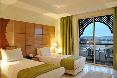 a hotel room with two beds and a balcony at Menzeh Zalagh City Center in Fès